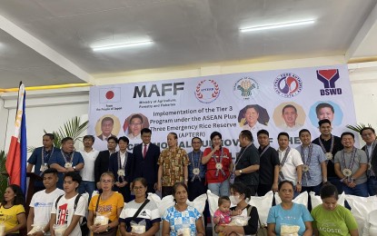 <p><strong>DONATION.</strong> Officials of the government of Japan, the Association of Southeast Asian Nations Plus Three Emergency Rice Reserve (APTERR), national and local government units in Albay, and families affected by the ongoing unrest of Mt. Mayon, pose for a photo opportunity during the turnover ceremony for 300 metric tons of rice donated by Japan's Ministry of Agriculture, Forestry, and Fisheries on Thursday (Aug. 17, 2023). The donation will be distributed to the 5,787 families displaced by the volcano's ongoing effusive eruption.<em> (PNA photo by Connie Calipay)</em></p>