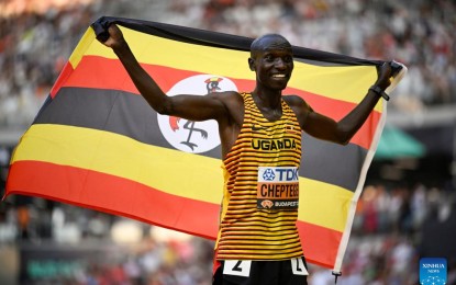 <p><strong>THIRD IN A ROW.</strong> Joshua Cheptegei of Uganda celebrates after winning the men's 10,000m final of the World Athletics Championships Budapest 2023 in Budapest, Hungary on Sunday (Aug. 20, 2023). Cheptegei won the title for third consecutive time and he said it might be his last title on the track.<em> (Xinhua/Song Yanhua)</em></p>