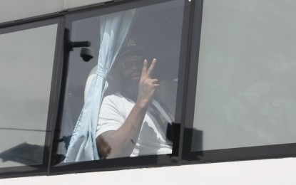 <p><strong>TEAM USA.</strong> A member of Team USA aboard a bus flashes the V sign to acknowledge the crowd after the powerhouse team arrived at the Ninoy Aquino International Airport Terminal 3 in Pasay City on Tuesday (Aug. 22, 2023). The US team is one of the top contenders for FIBA World Cup. <em>(PNA photo by Avito Dalan)</em></p>