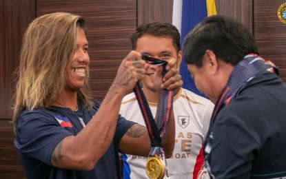 <p><strong>DRAGON BOAT</strong>. Ramoncito Noguera of Barangay Basak, Lapu-Lapu City dons Mayor Junard Chan the medals the Philippine Accessible Disability Service (PADS) Paradragon Elite Team won during the 16th World Dragon Boat Racing Championships held in Rayong, Pattaya, Thailand from August 7-13, 2023. Chan pledged to give recognition and incentives to the seven members of PADS who are natives of Lapu-Lapu City. <em>(Photo courtesy of Lapu-Lapu City PIO)</em></p>