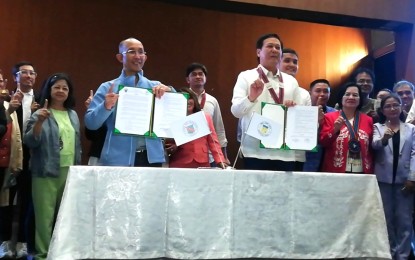 <p><strong>SISTERHOOD TIES.</strong> Baguio City Mayor Benjamin Magalong (left) and San Jose City, Nueva Ecija Mayor Mario Salvador (right) show the memorandum of agreement and sisterhood ties documents following the signing on Wednesday (Aug. 23, 2023) at the Baguio Convention Center, with officials from both cities as witnesses. Magalong says among the things they want to share with San Jose are the programs and activities they do as part of the three-year disaster resiliency grant received by Baguio.<em> (PNA photo by Liza T. Agoot)</em></p>