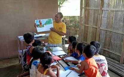 <p><strong>AWARD-WINNING.</strong> Iraynon Bukidnon tribe leader Abel Pedro gathers Indigenous Peoples (IPs) children for a storytelling activity on July 12, 2023. Antique Provincial librarian Grace Magullado, said in an interview Wednesday (Aug. 23) that the provincial library is an awardee in the 2023 Search for Gawad Pampublikong Aklatan Best Social Inclusion Activity for IP because of the storytelling community outreach program. (<em>PNA photo courtesy of Abel Pedro</em>)</p>