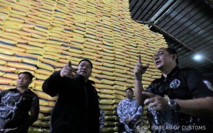 <p><strong>PADLOCKED.</strong> Bureau of Customs officials inspect one of three warehouses in Bulacan on Aug. 24, 2023, where they found PHP505 million worth of suspected smuggled rice. The warehouses were padlocked until the owners submit the required importation documents.<em> (Photo courtesy of BOC)</em></p>