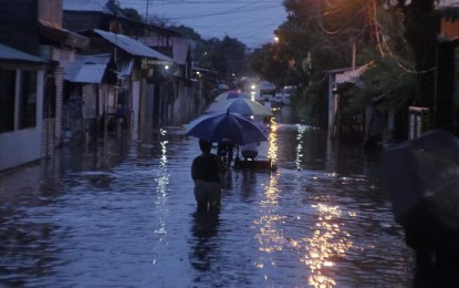 <p><strong>FLOODED</strong>. Residents of Bangga Lourdes, Barangay Pahanocoy in Bacolod City wade through flood waters on Monday evening (Aug. 28, 2023). As of Tuesday afternoon, at least 31 villages in the city’s 61 barangays have been hit by floods brought by monsoon rains enhanced by Typhoon Goring.<em> (Photo courtesy of Bacolod City PIO)</em></p>