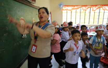 <p><strong>PAY HIKE</strong>. A teacher at President Corazon C. Aquino Elementary School in Quezon City makes the first day of classes joyful and memorable for her students in this photo taken on Aug. 29, 2023. Camarines Sur Rep. Luis Raymund Villafuerte Jr. said on Thursday (Dec. 28, 2023) a measure upgrading the minimum salary grade level of teachers from Salary Grade 11 to 19 would support President Ferdinand Marcos Jr.'s campaign promise of a salary increase. <em>(PNA photo by Joan Bondoc)</em></p>