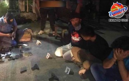 <p><strong>CHECKPOINT ARREST.</strong> A police investigator (left) documents the firearms recovered from a candidate for village chair and three others during a law enforcement operation in Barangay Bual, Midsayap, North Cotabato on Tuesday night (Aug. 29, 2023). The arrest came hours after another candidate for barangay chair was shot dead near the town hall after he filed his certificate of candidacy. <em>(Photo from Midsayap MPS via Radyo Bandera)</em></p>