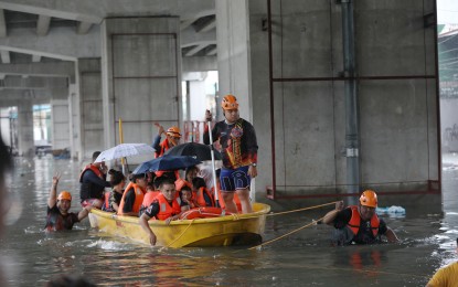 <p><strong>RESCUE</strong>. Rescuers evacuate stranded residents to higher grounds after a portion of Araneta Avenue in Barangay Tatalon, Quezon City was submerged in floodwaters on Thursday (Aug. 31, 2023). The Department of Social Welfare and Development immediately sent family food packs and other relief items to flood victims in Metro Manila following requests for augmentation support from local government units. <em>(PNA photo by Joey O. Razon)</em></p>