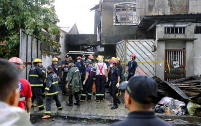 <p><strong>CHARRED.</strong> Bureau of Fire Protection and Quezon City Disaster Risk Reduction and Management Office personnel inspect the house razed by a fire in Tandang Sora, Quezon City on Thursday (Aug. 31, 2023). At least 16 persons were killed in the fire that was raised to first alarm at 5:44 a.m. and was declared out at 8:04 a.m. <em>(PNA photo by Joey O. Razon)</em></p>