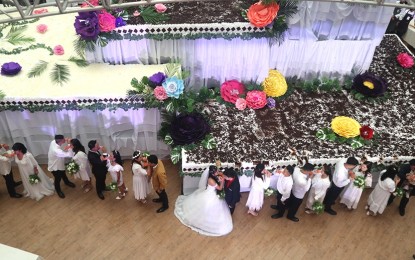 <p><strong>DESSERTS FOR ALL.</strong> The 11 couples who got married in a mass ceremony and other guests partake of the giant four-layer wedding cake at SM Baguio City on Saturday (Sept. 2, 2023), sponsored by the Hotel and Restaurant Association of Baguio and the city government. The cake has five flavors and was sliced into 12,000 pieces, distributed to the public. <em>(PNA photo by Liza T. Agoot)</em></p>
