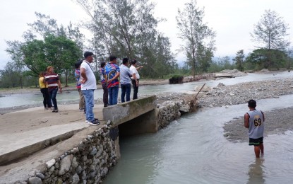 <p><strong>ISOLATED</strong>. An inspection team checks the situation of a damaged road in Solsona, Ilocos Norte that isolated three villages on Monday (Sept. 4, 2023). The municipality was placed in a state of calamity on the same day. <em>(Photo courtesy of Solsona LGU)</em></p>