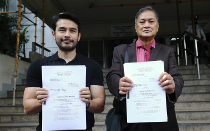 <p><strong>DAMAGE SUIT.</strong> Broadcast journalist Alfonso Tomas "Atom" Araullo (left) and counsel Tony La Viña show to the media a copy of damage complaint filed against former anti-insurgency task force spokesperson Lorraine Badoy and Jeffrey Celiz before the Quezon City regional trial court on Monday (Sept. 11, 2023). Araullo alleged that Badoy and Celiz linked him to communist terrorist groups. <em>(PNA photo by Joey O. Razon)</em></p>