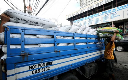 <p><strong>IMPORT TARIFF</strong>. A worker unloads sacks of rice from a delivery truck at Mega Q Mart in Quezon City on Monday (Sept. 11, 2023). The Department of Finance is proposing to reduce by 35 percent the rice import tariff rates, which could bring down the price of imported rice by as much as PHP6 per kilo. <em>(PNA photo by Joan Bondoc)</em></p>