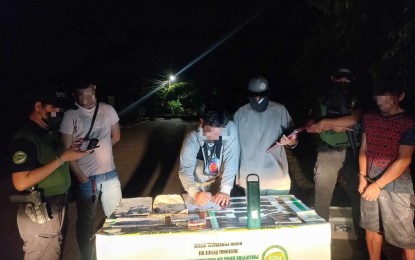 <p><strong>ANTI-DRUG OPERATIONS.</strong> Roger Niluag (right, with handcuffs) watches as members of the Philippine Drug Enforcement Agency-Bohol and Bohol Provincial Police Office conduct on-site inventory of the seized shabu worth PHP374,000 in Tagbilaran City on Monday (Sept. 11, 2023). Central Visayas police chief, Brig. Gen. Anthony Aberin, reported a total of PHP14 million worth of shabu were seized during the week-long anti-criminality operations. <em>(Photo courtesy of PDEA-7)</em></p>