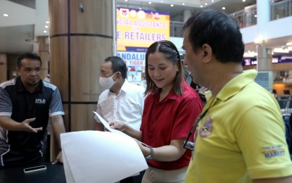 <p><strong>SUBSIDY</strong>. Chief of Staff Charisse Marie Abalos-Vargas (2nd from right) of the Mandaluyong City Mayor’s office, checks the list of the recipients of the PHP15,000 financial subsidy from the national government for micro rice retailers, during the distribution at the Mandaluyong City Hall on Wednesday (Sept. 13, 2023). President Ferdinand R. Marcos Jr. has instructed the Department of Social Welfare and Development to utilize its Sustainable Livelihood Program to help mitigate the expected financial difficulties faced by small rice vendors due to the temporary price cap. <em>(PNA photo by Joey O. Razon)</em></p>