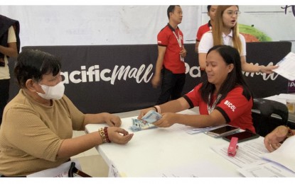 <p><strong>GOV'T SUBSIDY.</strong> Hilda Consulta (left), a small rice retailer from Tiwi Albay, receives PHP15,000 financial assistance from a Department of Social Welfare and Development-5 (Bicol) personnel at a mall in Legazpi City on Wednesday (Sept. 13, 2023). A total of 578 rice retailers in the region will be provided with government subsidies to help them cope with losses due to the imposition of rice price caps. <em>(PNA photo by Connie Calipay)</em></p>