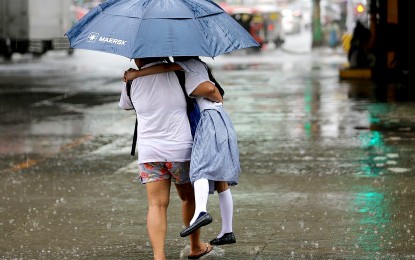 <p><strong>PROTECTED.</strong> Under a big umbrella and with her mother tightly carrying her, a young student will get home safe and dry amid a downpour on Sept. 12, 2023. The weather bureau on Thursday (Sept. 28, 2023) said the trough of a low pressure area, located 800 kilometers east of extreme Northern Luzon inside the Philippine Area of Responsibility, will bring rain showers over the Visayas and parts of Mindanao. <em>(PNA photo by Joan Bondoc)</em></p>