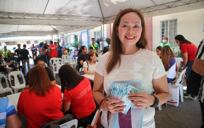 <p><strong>RICE SUBSIDY.</strong> Analisa Fabregas, a rice retailer at Toril Public Market in Davao City, receives the PHP15,000 rice subsidy under the Sustainable Livelihood Program of the Department of Social Welfare and Development in Davao Region. Fabregas thanked the national government for the aid and vowed to abide by Executive Order 39 on the rice price cap. <em>(PNA photo by Robinson Niñal Jr.)</em></p>