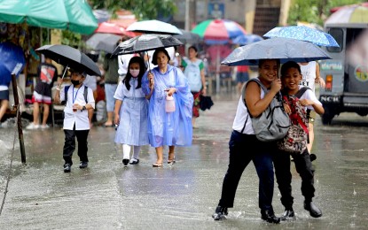 <p><strong>UNDER THEIR UMBRELLA.</strong> Two classmates having fun on their way home from Marcelo H. Del Pilar Elementary School in Quezon City despite the inconvenience of a sudden downpour on (Sept. 12, 2023. Some areas in Luzon will experience rain showers due to the shear line and the northeasterly surface windflow, the weather bureau reported Thursday (Oct. 19). <em>(PNA photo by Joan Bondoc)</em></p>