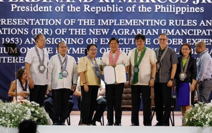 <p><strong>LEEWAY.</strong> President Ferdinand R. Marcos Jr. and Department of Agrarian Reform (DAR) Secretary Conrado Estrella III (4th and 5th from left) present the implementing rules and regulations of the New Agrarian Emancipation Act and Executive Order 40 that extends for two years or until Sept. 13, 2025 the moratorium on payments by farmer-beneficiaries, at the DAR central office gymnasium in Diliman, Quezon City on Sept. 12, 2023. The latest directive will benefit more than 129,000 beneficiaries tilling 158,209 hectares of land whose land awards did not reach the July 24 cutoff to qualify for the condonation of agrarian debt. <em>(PNA photo by Rey Baniquet)</em></p>