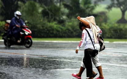 <p><strong>COVER-UP.</strong> A couple is not ready for the sudden rains at the University of the Philippines Diliman in Quezon City on Sunday afternoon (Sept. 17, 2023). A huge part of the country will experience rain showers brought by two weather systems, the weather bureau said Monday (Nov. 20, 2023). <em>(PNA photo by Joan Bondoc)</em></p>