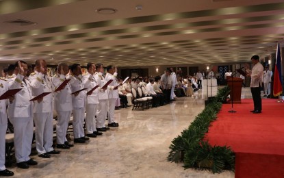 <p><strong>NEW POLICE GENERALS.</strong> President Ferdinand R. Marcos Jr. (right) leads the oath-taking of newly promoted generals of the Philippine National Police at the Heroes Hall of Malacañan Palace in Manila on Tuesday (Sept. 19, 2023). Marcos assured them of the government's continued support but also warned that there would be no room for leniency for police officers who engage in acts that tarnish the reputation of the organization and the safety of the public. <em>(PNA photo by Rey Baniquet)</em></p>