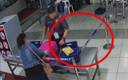<p><strong>'NO GIFT/TIPPING' POLICY.</strong> A CCTV footage shows a female passenger, a male security screening officer (SSO) and a pack of chocolates separated from the baggage last Sept. 13 at the NAIA Terminal 2. The SSO claimed the chocolates were given to him, but the Office for Transportation Security said it is a violation of their "no gift/tipping" policy. <em>(Photo courtesy of OTS)</em></p>