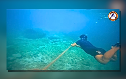 <p><strong>ILLEGAL.</strong> A Philippine Coast Guard personnel removes the floating barriers with an estimated length of 300 meters southeast of Bajo de Masinloc. Filipino fisherfolk reported that Chinese vessels usually install floating barriers whenever they see local boats in the area.<em> (Photo courtesy of PCG)</em></p>