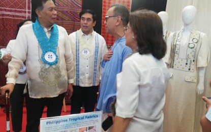 <p><strong>BAMBOO YARN</strong>. Department of Science and Technology Undersecretary for Regional Affairs Sancho Mabborang (left) and Philippine Textile Research Institute director Julius Leano Jr. (2nd from left) speak with a designer at the Regional Science and Technology Innovation Exhibit in Bangued, Abra on Wednesday (Sept. 27, 2023). The agency is working with the Abra State Institute of Science and Technology to put up a bamboo textile hub that will reinforce the traditional weaving by producing bamboo fiber for yarn. <em>(PNA photo by Liza T. Agoot)</em></p>