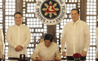 <p><strong>'TRABAHO PARA SA BAYAN'.</strong> President Ferdinand R. Marcos Jr. (center) signs into law on Wednesday (Sept. 27, 2023) the “Trabaho Para sa Bayan Act,” which aims to address unemployment, underemployment and other challenges in the labor market, during ceremonies at the Kalayaan Hall of the Malacañan Palace. The law will focus on improving the employability and competitiveness of Filipino workers through upskilling and reskilling initiatives; and support micro, small, and medium enterprises and industry stakeholders. <em>(PNA photo by Rey Baniquet)</em></p>