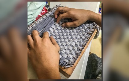 <p><strong>INCOME GENERATING PROJECT</strong>. A resident of Iloilo City’s Dalayunan: A Home for Boys weaves a doormat in this undated photo. The center is calling for donations of raw materials to sustain the doormat and potholder projects, which give the residents the opportunity to earn. <em>(PNA photo from Dalayunan FB page)</em></p>