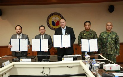 <p><strong>PARTNERSHIP.</strong> Commission on Elections (Comelec) Chairperson George Erwin Garcia (2nd from left) holds a signed memorandum of agreement (MOA) with Department of National Defense (DND) Secretary Gilberto Teodoro Jr. (center) and AFP chief Gen. Romeo Brawner Jr. (2nd from right), during the signing ceremony held at the Department of National Defense, Camp General Emilio Aguinaldo in Quezon City on Thursday (Sept. 28, 2023). The MOA aims to boost their partnership in support of the poll body's campaign for the Barangay and Sangguniang Kabataan Elections. <em>(Photo courtesy of Comelec)</em></p>