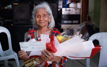 <p><strong>LONG LIFE</strong>. Centenarian Maura Agripa shows the PHP100,000 check she receives from the Taguig City government on her 100th birthday on Sept. 26, 2023. The Department of Social Welfare and Development on Tuesday (Oct. 31, 2023) announced that a total of 12,186 centenarians have received PHP100,000 incentives from the national government through DSWD from 2017 up to September this year. <em>(Photo courtesy of Taguig PIO)</em></p>
