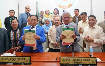 <p><strong>EMPOWERMENT.</strong> BARMM Chief Minister Ahod Balawag Ebrahim and Bangsamoro Transition Authority (BTA) Speaker Pangalian Balindong hold copies of the new law on local governance at the Bangsamoro Government Center in Cotabato City. Members of the Bangsamoro parliament joined them shortly after passing the Bangsamoro Local Governance Code on its third and final reading on Thursday night (Sept. 28, 2023). <em>(Photo courtesy of BTA-BARMM)</em></p>