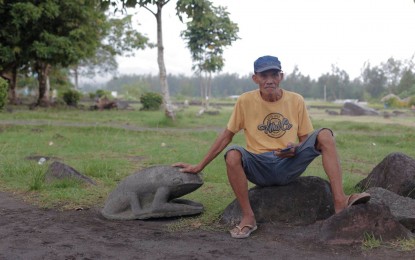 <p><strong>MASTER OF MAYON ART STONE</strong>. Vicente “Enteng Bato” Ajero of Daraga, Albay showcases his lava rock sculpture 'Big Frog' on Sunday (Oct. 1, 2023). For the lava rock artist, all it takes is a hammer, a nail, and a healthy dose of imagination to transform ordinary volcanic stones into stunning works of art.<em> (Photo courtesy of Lhal Baldo)</em></p>