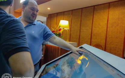 <p><strong>ELECTRONIC MEDIA BOARD</strong>. Negros Oriental Governor Manuel L. Sagarbarria tries his hand on the modern touch-screen media board that contains vital information for tourists. The provincial government, through the Provincial Tourism Board, launched on Monday afternoon (Oct. 2, 2023) the new Tourism Information Center at the Dumaguete-Sibulan airport<em>. (Photo courtesy of the Provincial Tourism Board Facebook)</em></p>