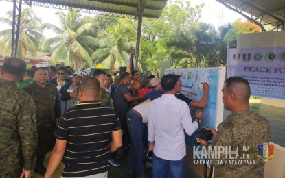 <p><strong>POLL STAKEHOLDERS.</strong> Security officials and candidates for Barangay and Sangguniang Kabataan Elections (BSKE) sign the “Wall of Commitment” on Wednesday (Oct. 4, 2023) in Carmen, North Cotabato, in support of the peaceful conduct of the political exercise on Oct. 30, 2023. The Army’s 6th Infantry Division says more peaceful dialogues will be conducted in its area of responsibility in Central Mindanao. <em>(Photo courtesy of 6ID)</em></p>