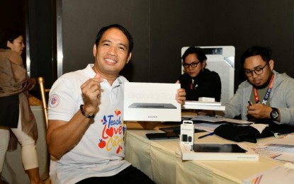 <p><strong>TEACHER'S DAY. </strong> One of the teachers of public schools in Taguig shows his new gadget received from the city government. More than 6,000 teachers were rewarded with tablets complete with keyboards and pens during the celebration of World Teacher's Day last Friday (Oct. 6, 2023).  <em>(Photo courtesy of Taguig City government) </em></p>