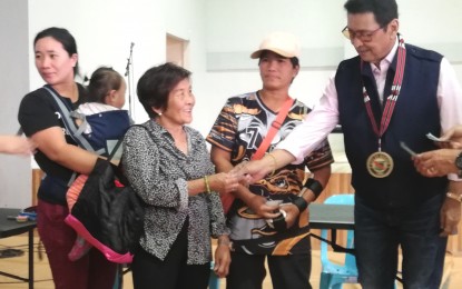 <p><strong>ASSISTANCE</strong>. Senator Lito Lapid (right) hands over to a recipient the cash aid to 333 heads of families (PHP3,000 each), and 200 students (PHP5,000 education assistance) from Baguio City. The grant is given through the Assistance to Individuals in Crisis Situation (AICS) of the Department of Social Welfare and Development. <em>(PNA photo by Liza T. Agoot)</em></p>