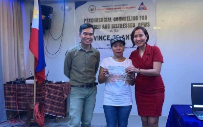 <p><strong>ASSISTANCE.</strong> A displaced overseas Filipino worker from Antique receives financial assistance from Overseas Worker Welfare Administration (OWWA) OIC-regional director Rizza Joy Moldes (right) and Darius Montaño (left) at the Kinaray-a Hotel, San Jose de Buenavista on Oct. 6, 2023. OWWA Officer II Remon Albeza said in an interview Monday (Oct. 9) that 22 distressed and displaced OFWs received a total of PHP1.3 million to help them restart their lives in the province. (<em>PNA photo courtesy OWWA6</em>)</p>