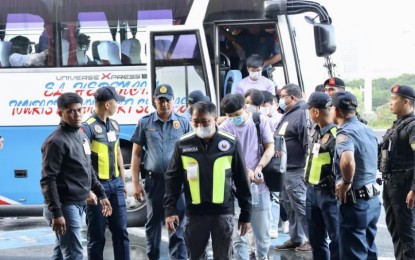 <p><strong>EJECTED</strong>. Cops escort Chinese nationals found working at an illegal Philippine Offshore Gaming Operator hub in Pasay City in this undated photo. Thirty-six of the workers were deported on Friday (Oct. 13, 2023).<em> (Photo courtesy of Chinese Embassy in Manila)</em></p>