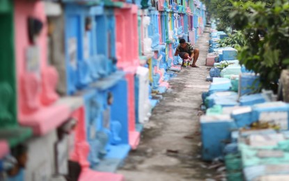 <p><strong>EARLY PREPS.</strong> A caretaker paints tombs at the Manila North Cemetery on Oct. 14, 2023. The Department of Health on Monday (Oct. 30, 2023) urged the public not to bring small children to cemeteries to keep them from getting injuries and catching diseases from overcrowding.<em> (PNA photo by Joan Bondoc)</em></p>