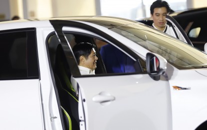 <p><strong>GOING GREEN.</strong> President Ferdinand R. Marcos Jr. tries one of the e-vehicles that will be introduced in the Philippine market by Dongfeng Motors at the brand launching held at the Metrotent in Pasig City on Monday (Oct. 16, 2023). Marcos urged the private sector to invest in electric vehicle manufacturing facilities in the country to generate more employment opportunities and foster more environmentally friendly communities. <em>(PNA Photo Alfred Frias)</em></p>