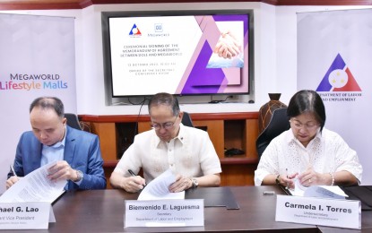 <p><strong>PARTNERSHIP.</strong> Labor Secretary Bienvenido Laguesma (center) and Megaworld Lifestyle Malls assistant vice president Michael Lao (left) sign a memorandum of agreement at the DOLE main office in Manila on Oct. 13, 2023. Under the pact, Megaworld Lifestyle Malls as an official partner venue of satellite job fairs and other DOLE-initiated activities under a rent-free arrangement. <em>(Photo courtesy of DOLE)</em></p>