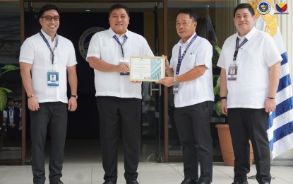 <p><strong>RECOGNITION.</strong> Customs Commissioner Bien Rubio (2nd from left) hands over a certificate of commendation to Deputy Commissioner for Intelligence Juvymax Uy (2nd from right) during flag-raising rites at the BOC grounds in Manila on Monday (Oct. 16, 2023). Also in photo are CIIS Director Verne Enciso (right) and acting Deputy Commissioner for Internal Administration Group Michael Fermin (left).<em> (Photo courtesy of BOC)</em></p>