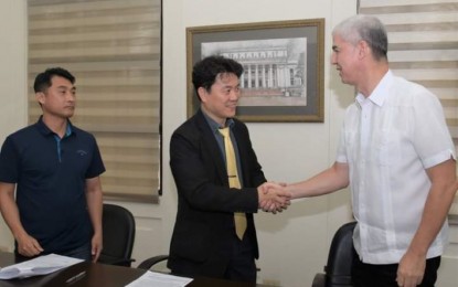 <p><strong>PARTNERSHIP.</strong> Negros Occidental Governor Eugenio Jose Lacson (right) shakes hands with  ThinkforBL chief executive officer Ji Hwan Park in the presence of In Hwan Shin (left), regional president of Bacolod of the United Korean Community Association in the Philippines, after signing the memorandum of agreement at the Provincial Capitol in Bacolod City Monday (Oct. 16, 2023). The partnership will involve the conduct of a research or demonstration trial on dairy production using the Milk-T Artificial Intelligence Technology developed by the Korean firm at the Provincial Livestock Breeding Center and Dairy Farm in La Carlota City. (<em>Photo courtesy of PIO Negros Occidental</em>)</p>