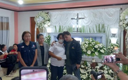 <p><strong>COMFORT FOR ALACRE FAMILY</strong>. Overseas Workers Welfare Administration Administrator Arnaldo “Arnell” Ignacio (right) comforts one of the sisters of Loreta Alacre, the Negrense caregiver killed in the Hamas attacks in Israel, at her wake in their family home in Barangay Cadiz Viejo, Cadiz City, Negros Occidental Monday afternoon (Oct. 23, 2023). The OWWA will help complete the construction of the house being built by Loreta through her remittances as an overseas Filipino worker for 15 years in Israel. (<em>Photo courtesy of Local Government Unit-Cadiz City</em>)</p>