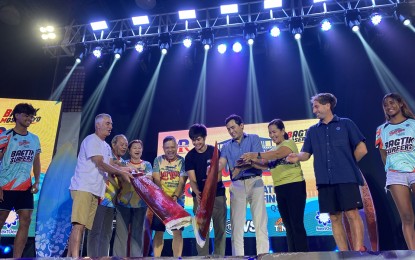 <p><strong>SURFING TOURNEY OPENS.</strong> Department of Tourism Undersecretary Shahlimar Hofer Tamayo (4th right), together with Presidential Son Vinny Marcos, Surigao del Norte 1st District Rep. Francisco Jose Matugas II, and General Luna town Mayor Sol Matugas (5th, 6th,7th from right, respectively), leads the ceremonial breaking of a surfboard on Wednesday evening (Oct. 26, 2023), signaling the opening of the 27th Siargao International Surfing Cup in General Luna, Surigao del Norte. At least 100 surfers from various nations and the Philippines will compete in the international tourney, which will conclude on Nov. 1. <em>(PNA photo by Alexander Lopez)</em></p>