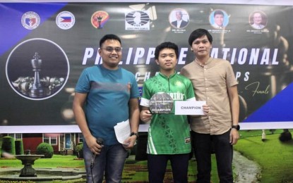 <p><strong>CHESS. </strong>Mark Jay Daños Bacojo (center) holding a trophy during one of his tournaments last year. Also in photo are FIDE Arbiter Jay Pattugalan (left) and International Arbiter Reden Cruz. <em>(Contributed photo) </em></p>