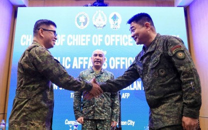 <p><strong>NEW AFP PAO CHIEF.</strong> Col. Xerxes Trinidad (right) and Lt. Col. Enrico Gil Ileto (left), the incoming and outgoing chiefs of the AFP Public Affairs Office, respectively, shake hands during the turnover rites in Camp Aguinaldo, Quezon City on Friday (Oct. 27, 2023). Trinidad served as Army spokesperson before being named as the new AFP PAO chief.<em> (Photo courtesy of the AFP)</em></p>