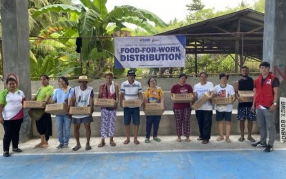 <p><strong>FOOD FOR WORK.</strong> Some of the 6,741 families receive family food packs (FFPs) from the Department of Social Welfare and Development (DSWD)-Central Visayas after participating in its food-for-work program. DSWD-7 regional director Shalaine Marie Lucero on Wednesday (Nov. 1, 2023) said the families joined the tree planting and declogging of waterways in exchange for FPPs from the agency. <em>(Photo courtesy of DSWD-7)</em></p>